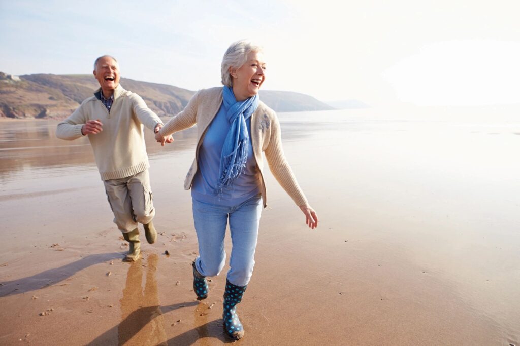Man and a woman on a beach laughing